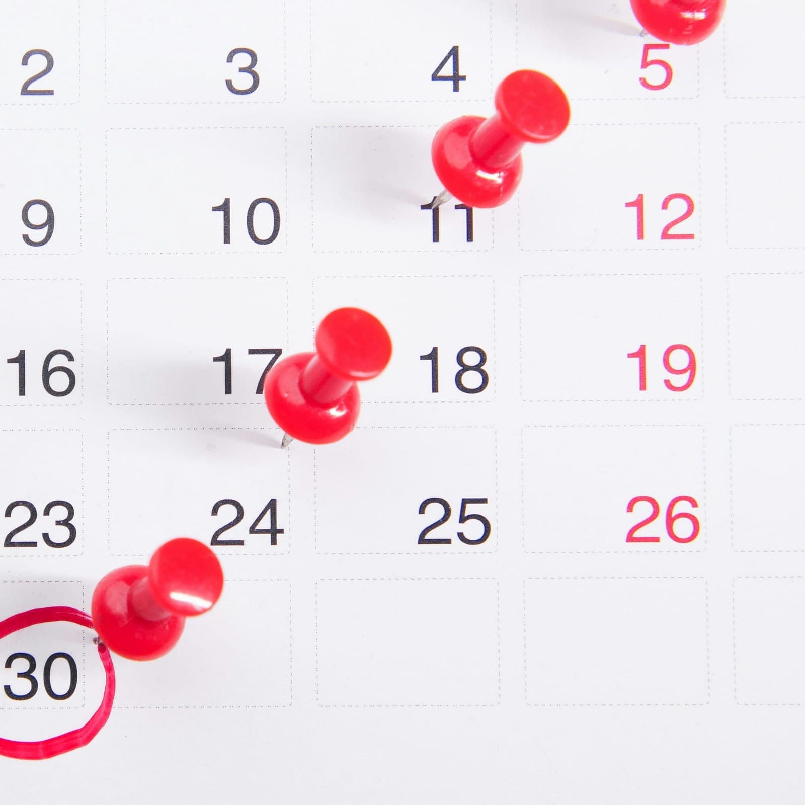 Red pins marking appointment dates on a calendar