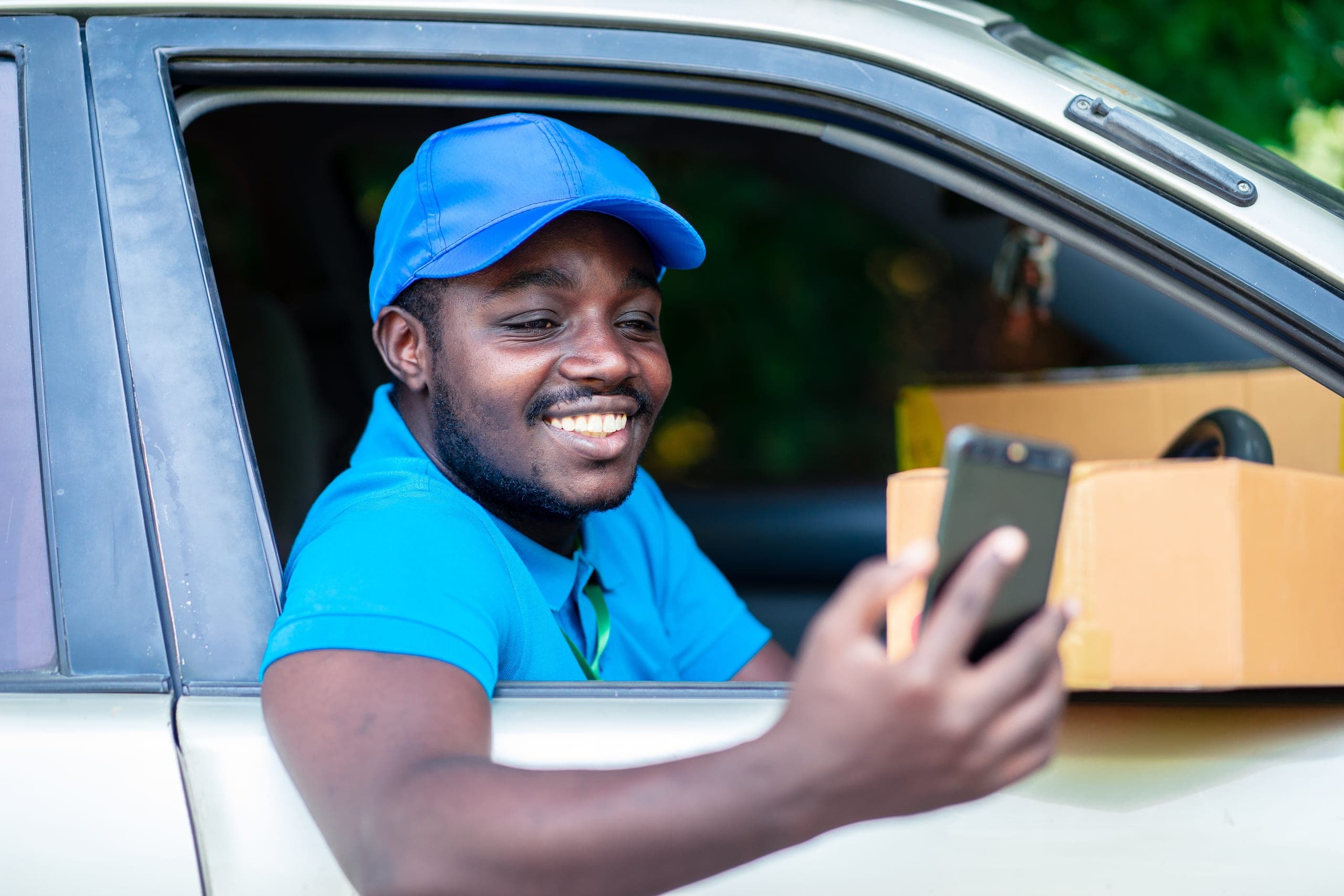 Delivery driver smiling at his phone in his van