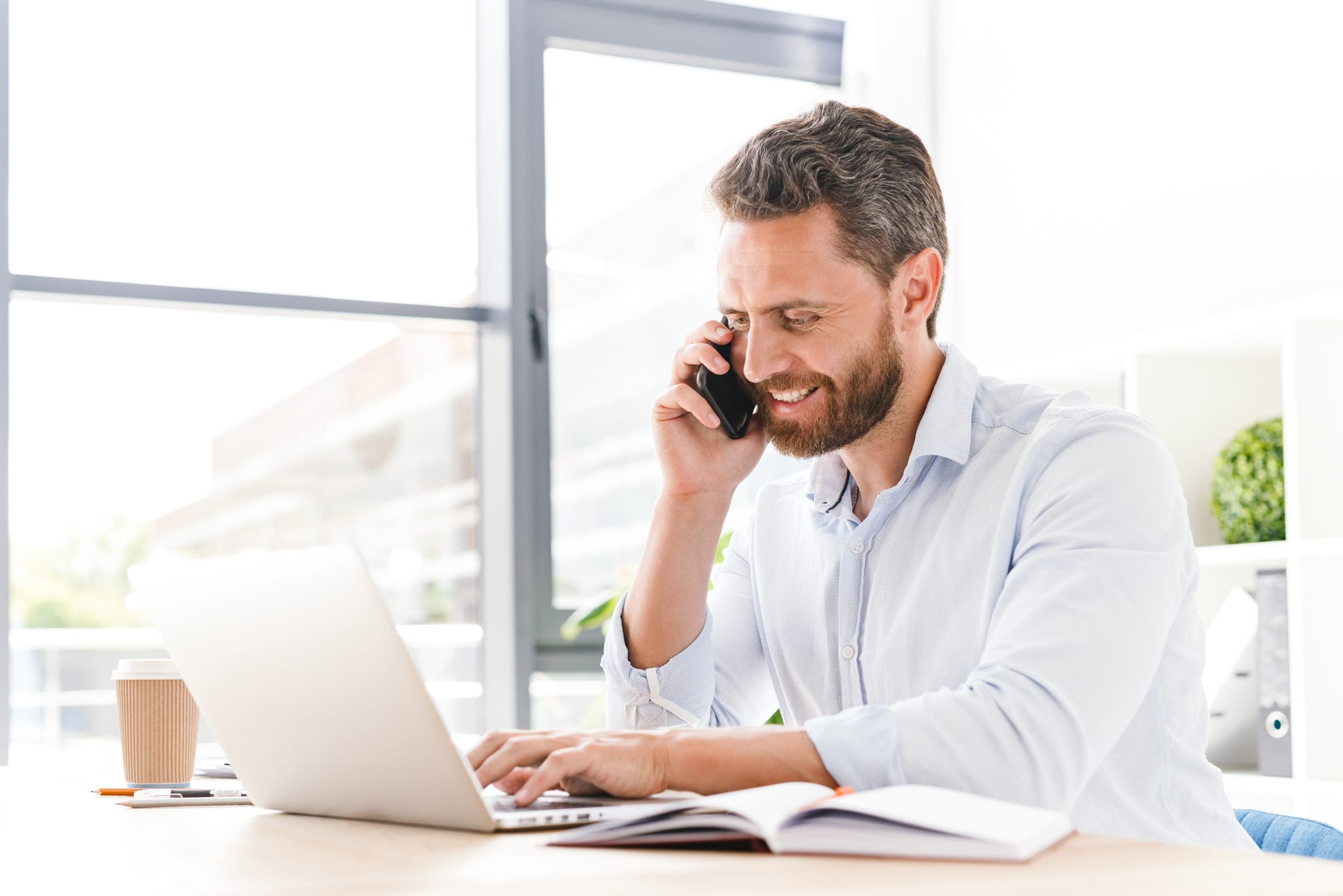 Man on the phone at his laptop