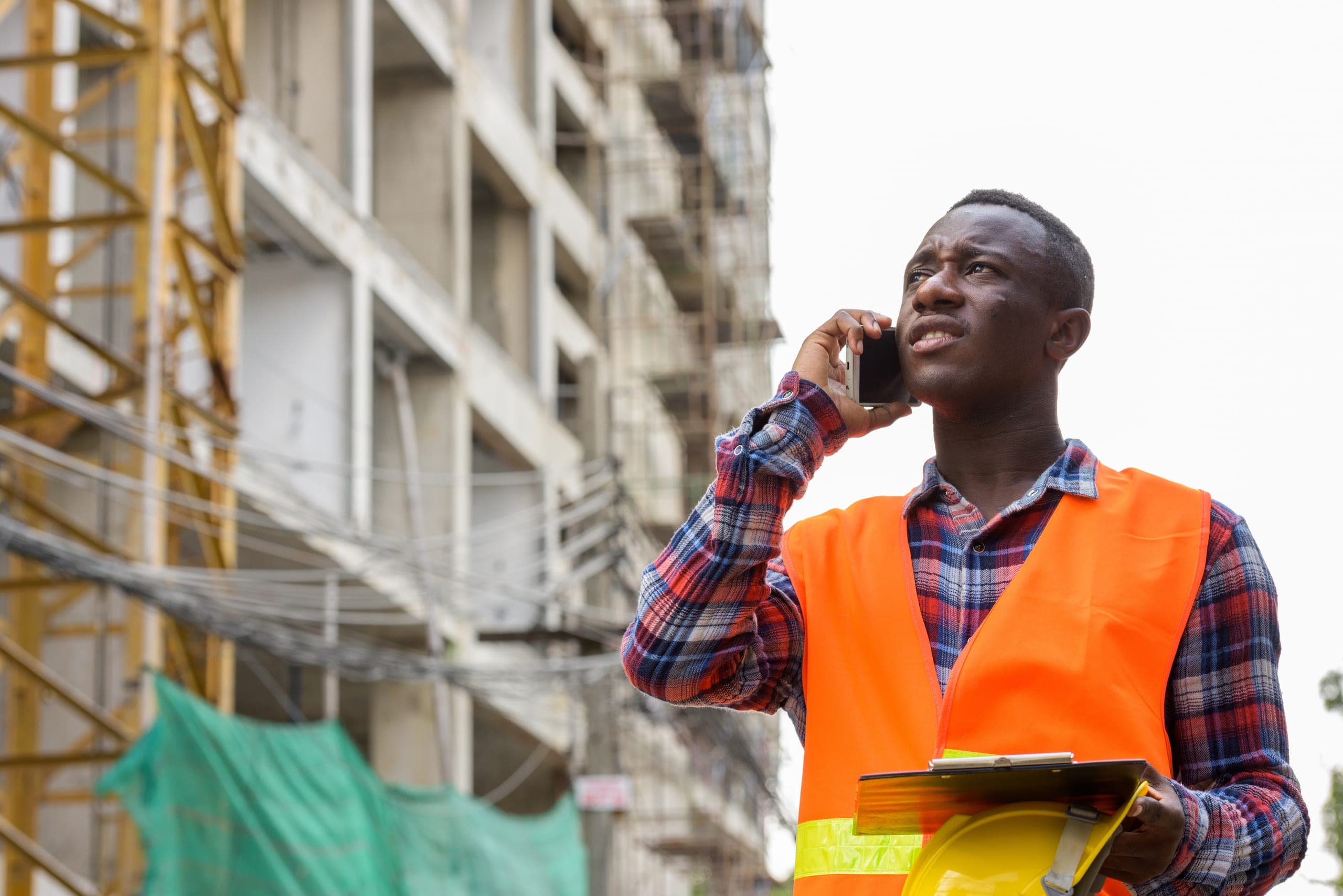 Construction worker on the phone outside a building