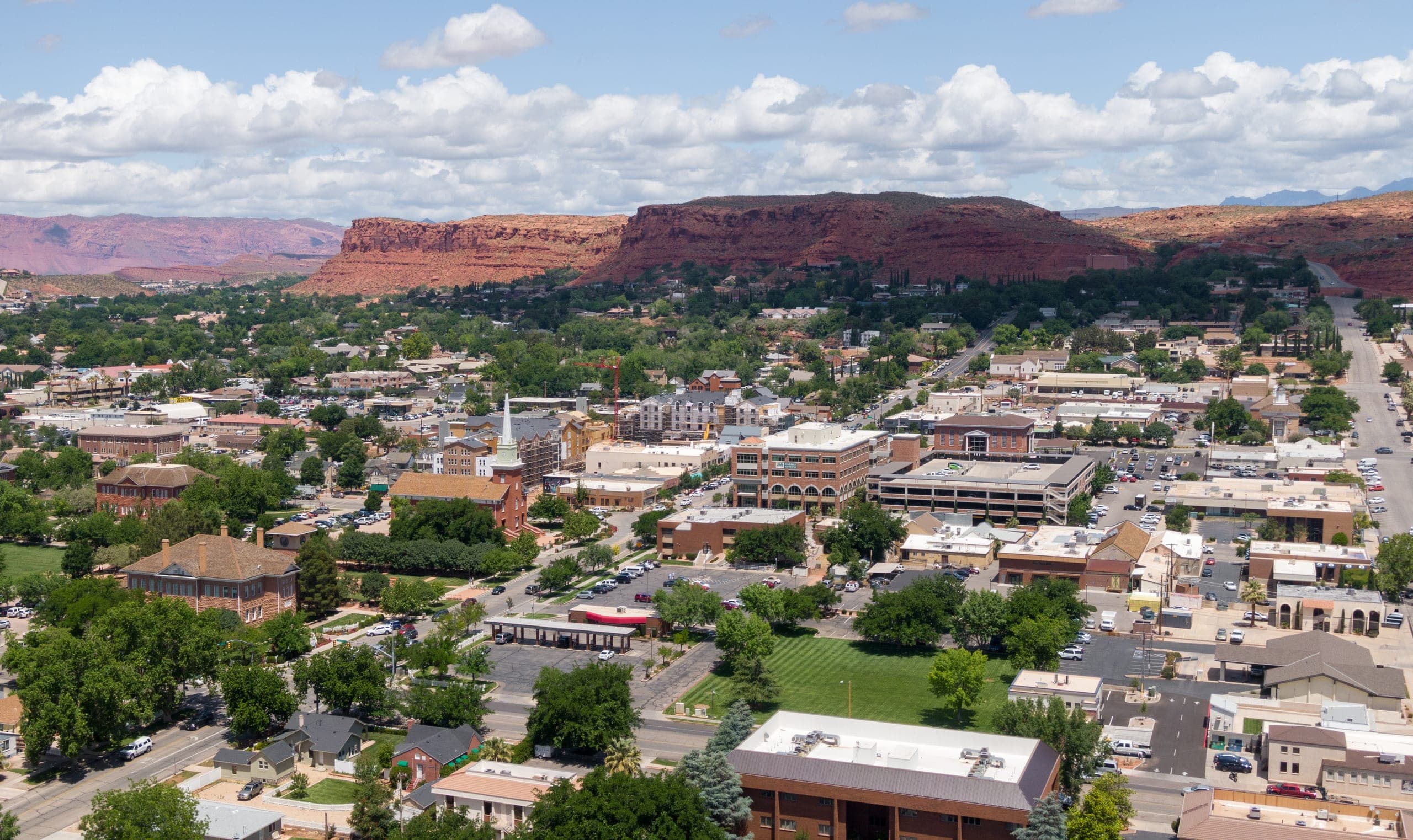 A southern Utah downtown with red cliffs behind it