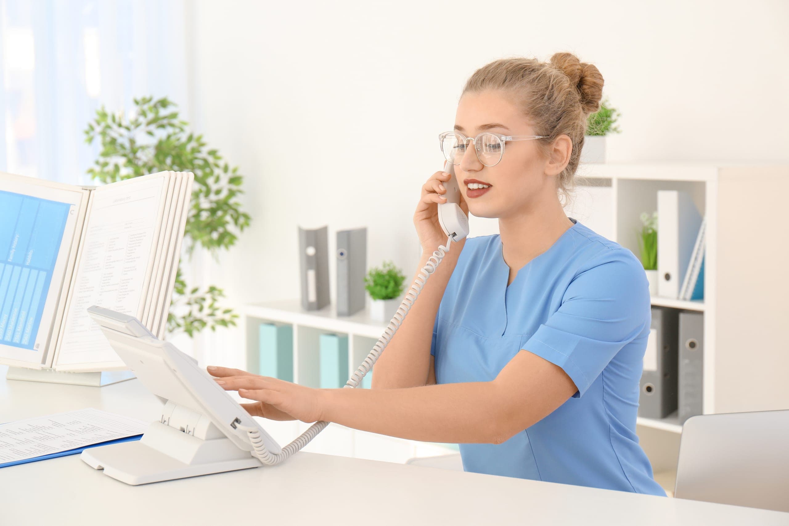 Hospital receptionist on the phone at her desk